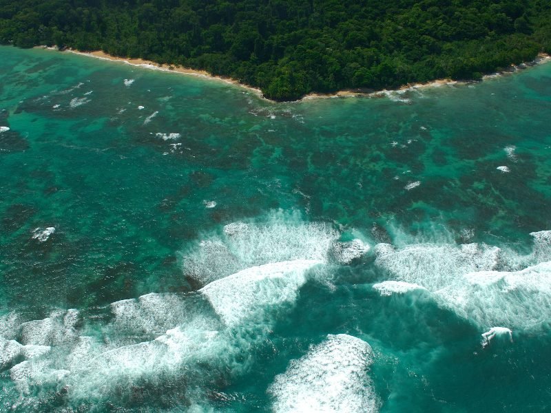 aerial view of books del toro's islands as seen from a drone with waves coming in off the shore