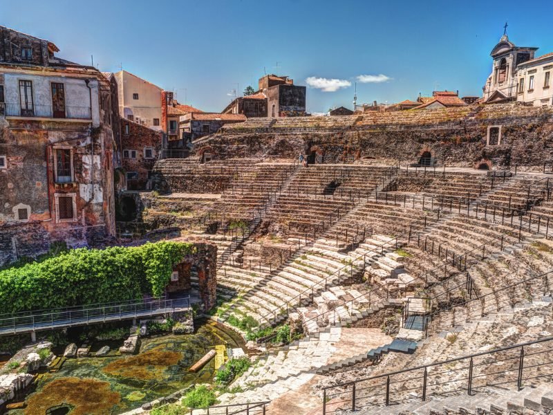 The ancient Greek-Roman theater in Catania Sicily in the center of town, showing limestone and black lava rock stairs