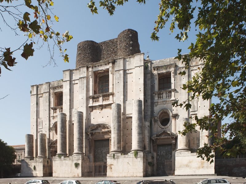 The church at Monstero dei Benedettini di San Nicolo with pillars, stonework, and three doors and three large windows