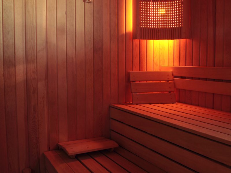 Wooden sauna with soft light and wooden pillow rests