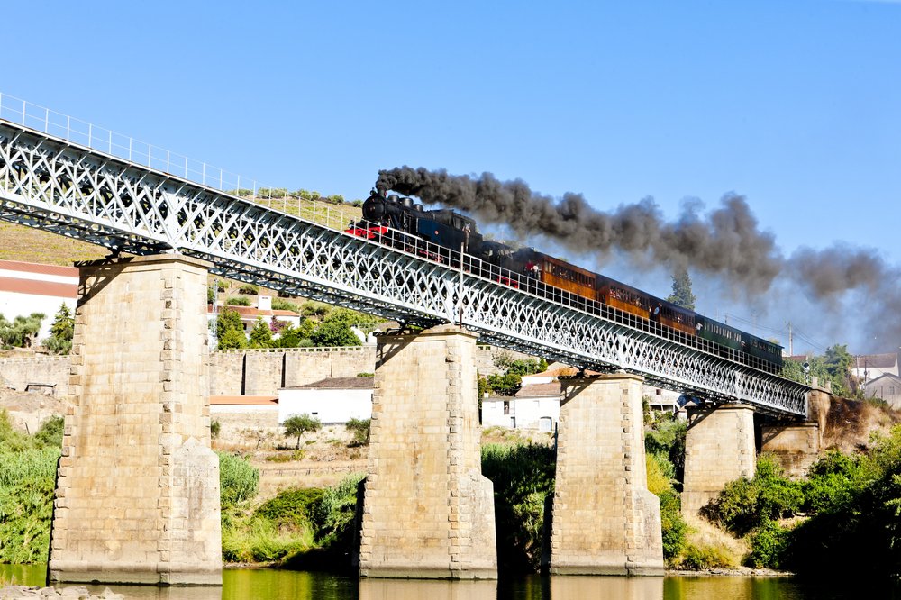 The historic steam powered train in Douro Valley on a bridge over the river