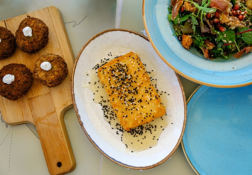 Kolokithokeftedes (zucchini fritters) and fried halloumi cheese covered in honey and sesame seeds and salad, at an Athens cooking class