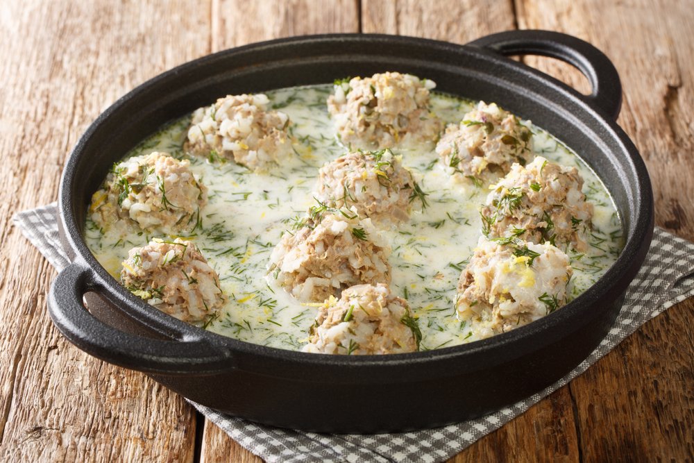 Youvarlakia is a Greek Meatball Soup, a flavorful dish of seasoned meatballs with creamy dill sauce, shown close-up in a plate on the table