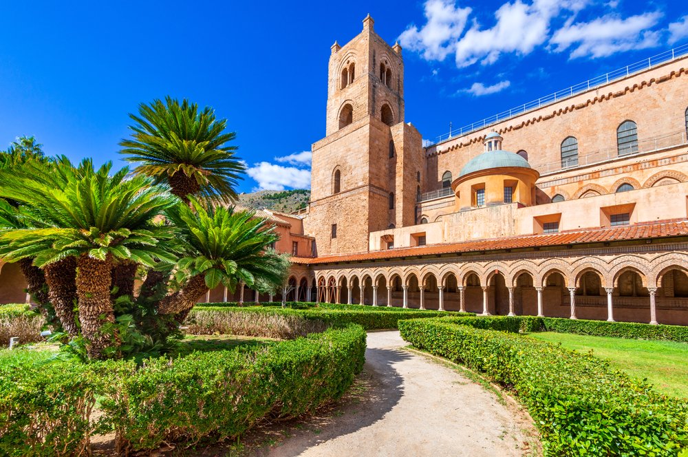 Monreale, Palermo. Norman-Byzantine cathedral in Sicily, part of a major UNESCO site, with hedges, and major archways around the perimeter of the cathedral