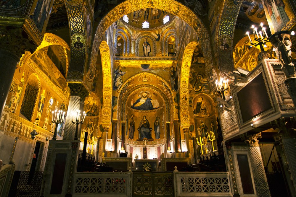 Interior of the Palatine Chapel of Palermo, with gold Byzantine era mosaic and lots of detailed work, arches, and design