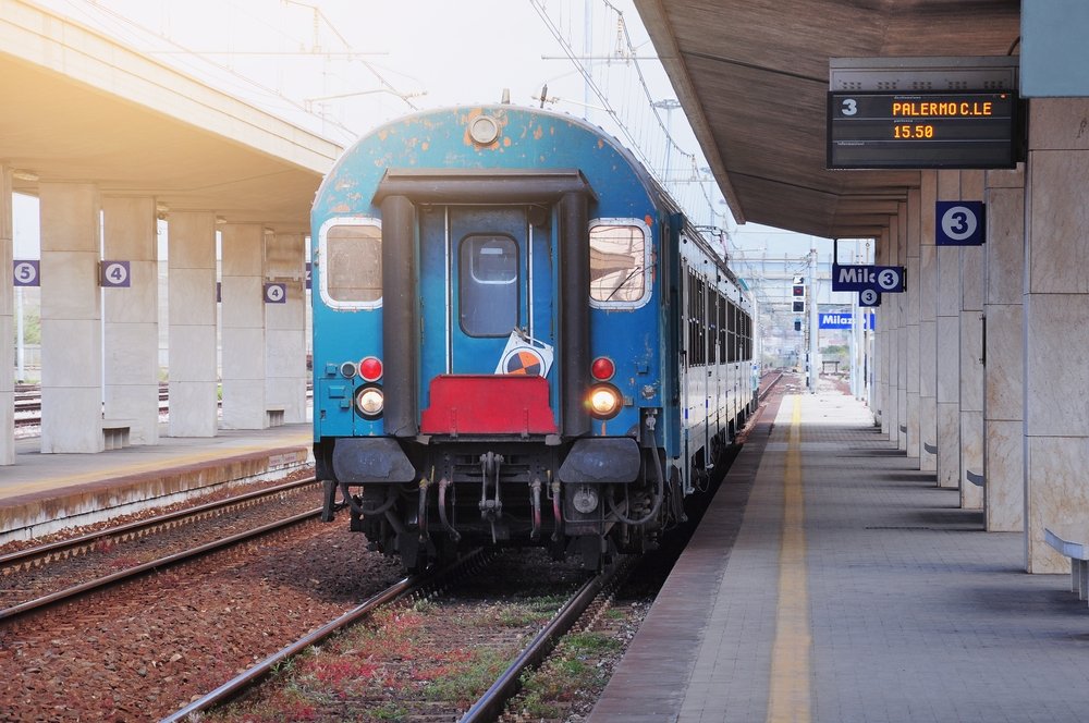 Blue and red train on track 3 that is going to Palermo centrale at 15:50 