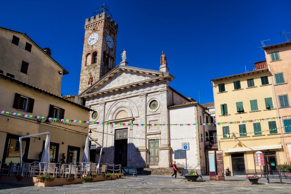 panorama in the old town of Poggibonsi, italy, in the town square with a spire, clock tower, church, and other old historic buildings on the piazza