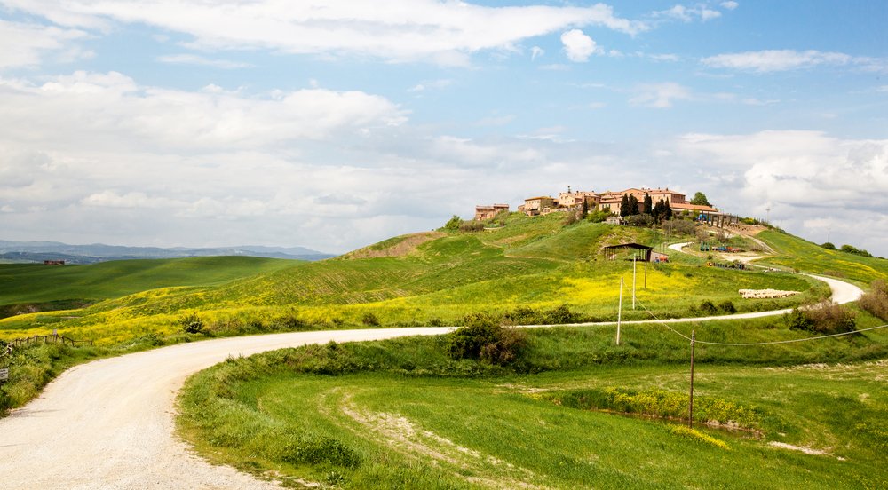 A road in tuscany going through the landscape