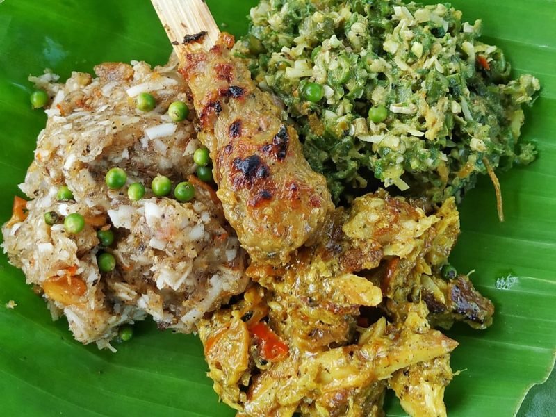 Balinese lilit sate with mixed veggies served on a banana leaf