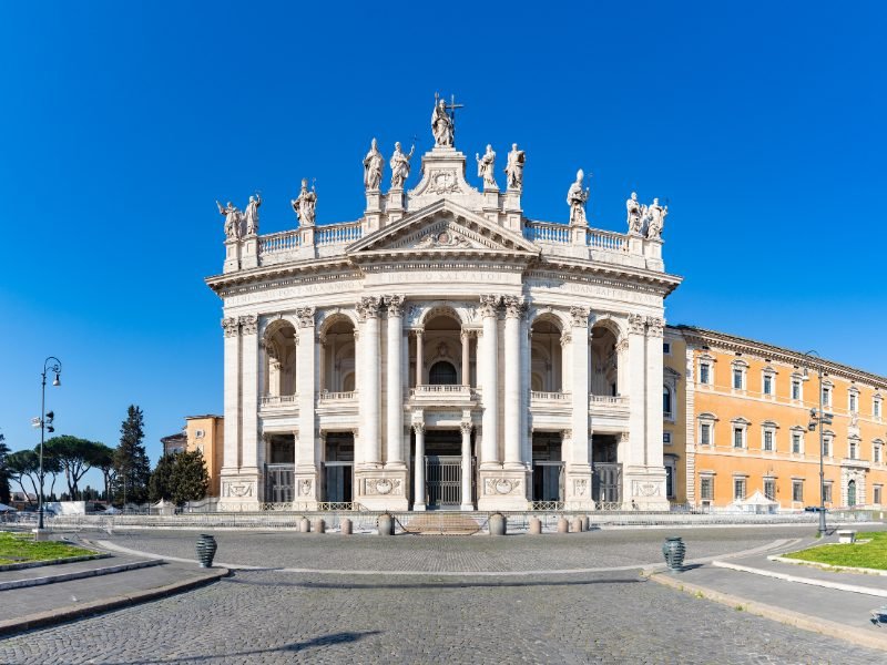 The famous Archbasilica outside the vatican walls, with ornate facade with several pillars and statues on the top of the church facade