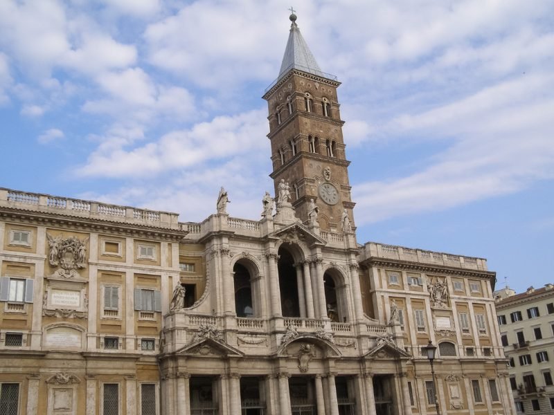 Ancient church of Basilica of St Mary Major, Santa Maria Maggiore, with a clocktower and church facade and taupe stonework