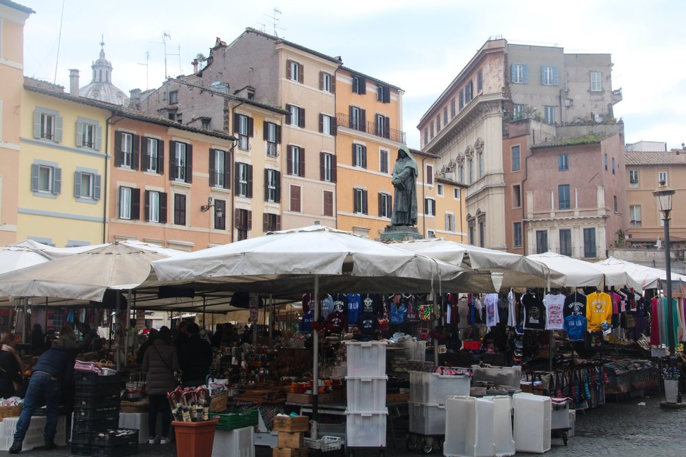 Colorful Campo de Fiori street market and the statue of the philosopher Giordano Brun standing above all the market stalls
