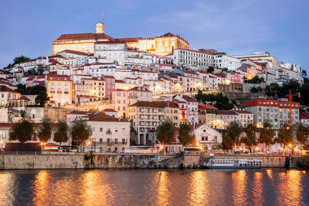 Beautiful and historic Coimbra cityscape with university at top of the hill in the evening