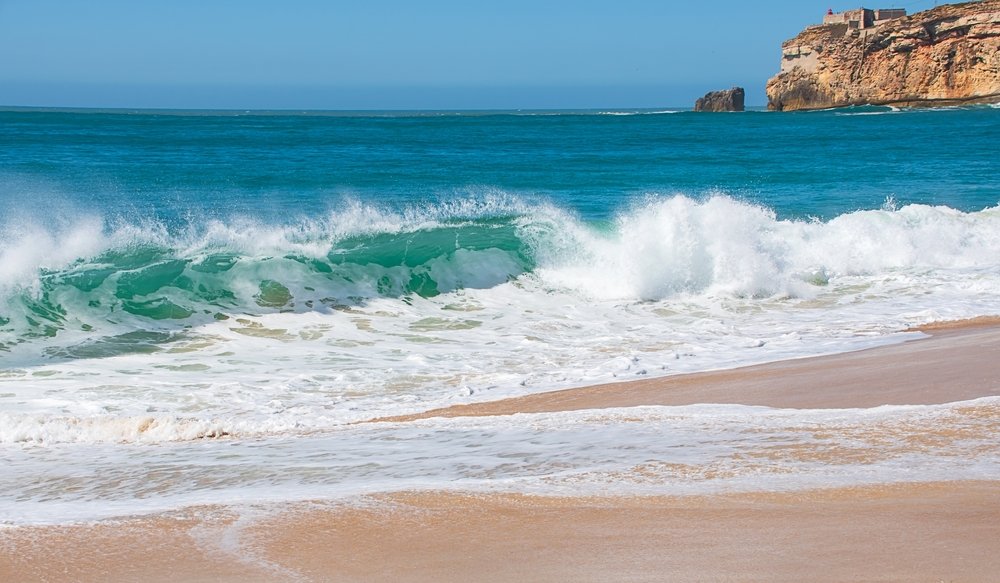 View of the Farol de Nazare lighthouse, high waves, Nazare, Portugal, Europe.