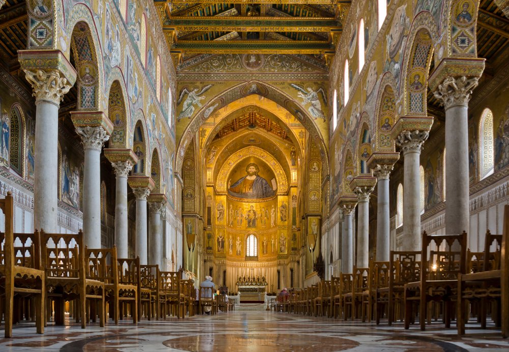 Monreale, Sicily, cathedral. Interior with nave, altar, and choir, with gold central area and white pillars and wooden chairs