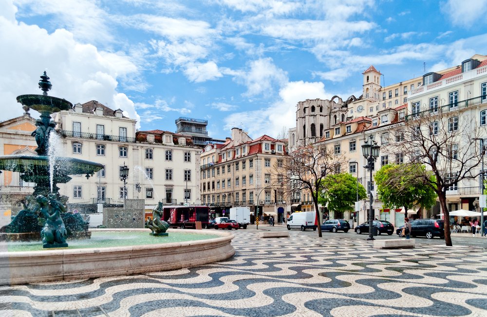 Rossio square with fountain and wavy black-and-white mosaic floor, located at Baixa district in Lisbon, Portugal