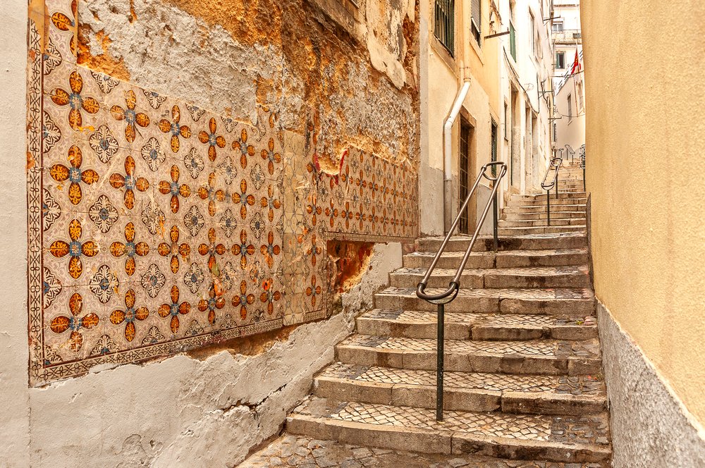 view of an old tiled street in alfama, the oldest neighborhood of lisbon that was not destroyed during the earthquake