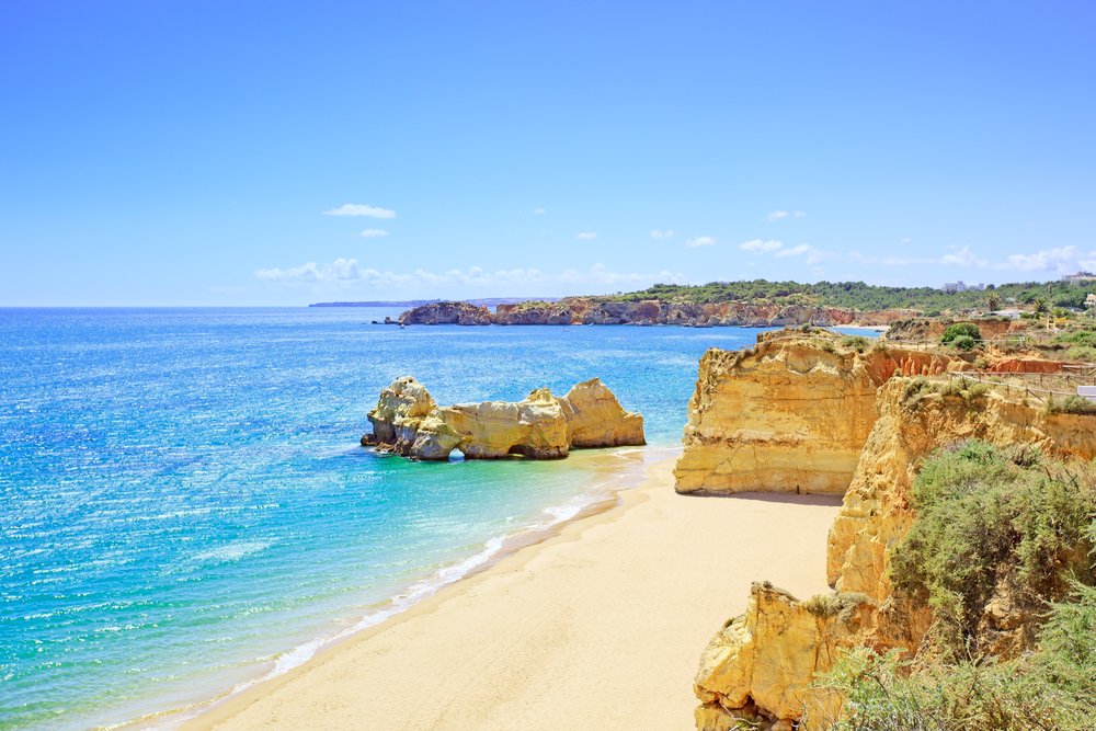 Beach and rock formation known as Praia da Rocha in travel destination Portimao on a sunny summer day with no one on the beach, peaceful day.
