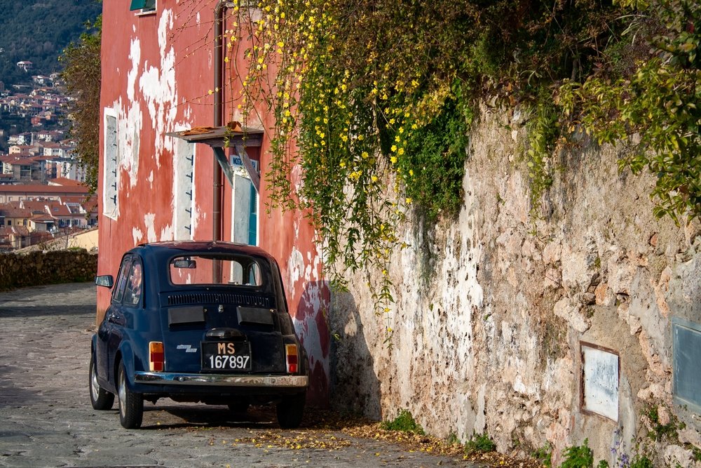 Old vintage car on a street of Tuscany, a small car suitable for small roads