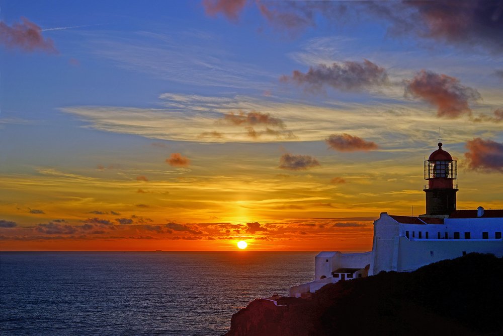 A silhouette of the Cabo Sao Vicente Lighthouse at sunset near Sagres while on a road trip from Lisbon to the Algarve