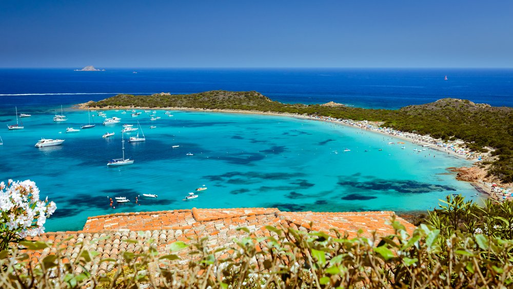 Clear sea water with white yachts and boats on Capo Coda Cavallo Beach (which means Tail of the horse) in San Teodoro, a Sardinia beach town