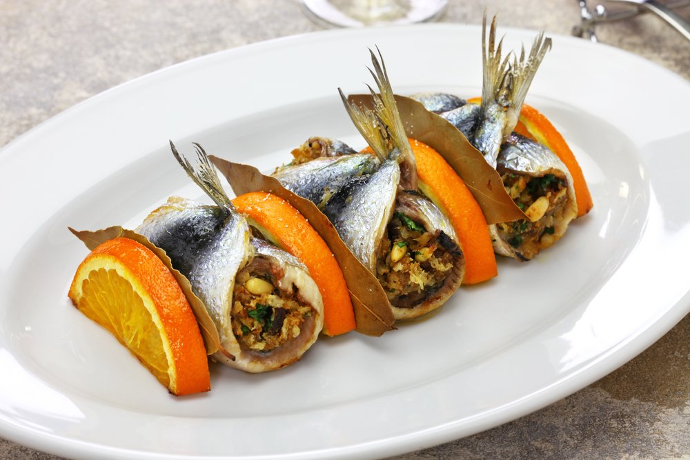 Stuffed anchovy rolls with pine nuts and slices of oranges between them