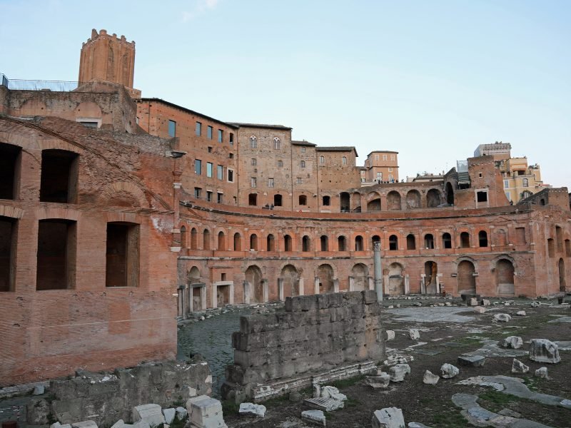 Old brickwork of the Trajan's Market, with red bricks and ruins on the ground, near the Roman Forum, another popular Rome landmark