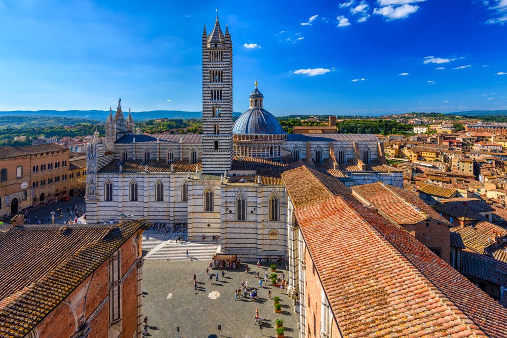 View of the famous striped facade of the church in Siena as seen from a rooftop terrace area as an aerial view over the city