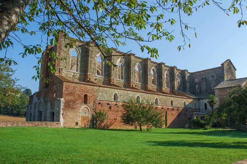 General view south side of the magical ruins of Saint Galgano Abbey, in the springtime with lush grass and trees