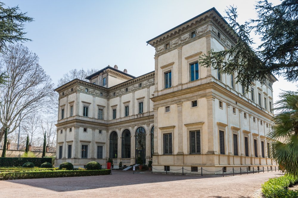 White building with square-like architecture in the middle of a park.  Villa Farnesina is a monument of architecture and painting of the High Renaissance, it's also a lesser-visited museum and a true Rome hidden gem.