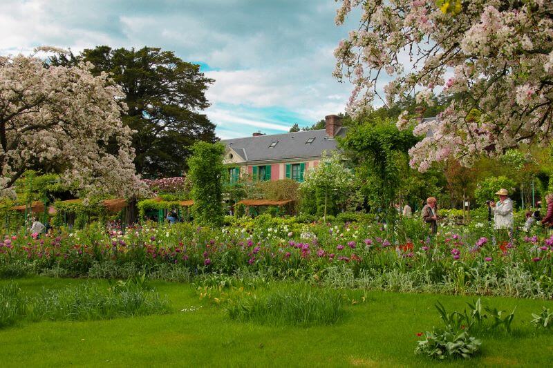 the gardens of claude monet the famous french painter with tourists taking photographs and visiting his house in the village of giverny