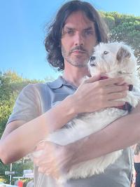 The Author Leo McPartland who writes about Barcelona and has been living there for over a decade holding a white dog