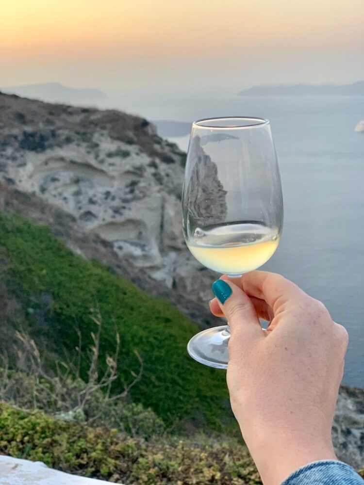 Venetsanos winery with Allison Green's hand holding a glass of white wine