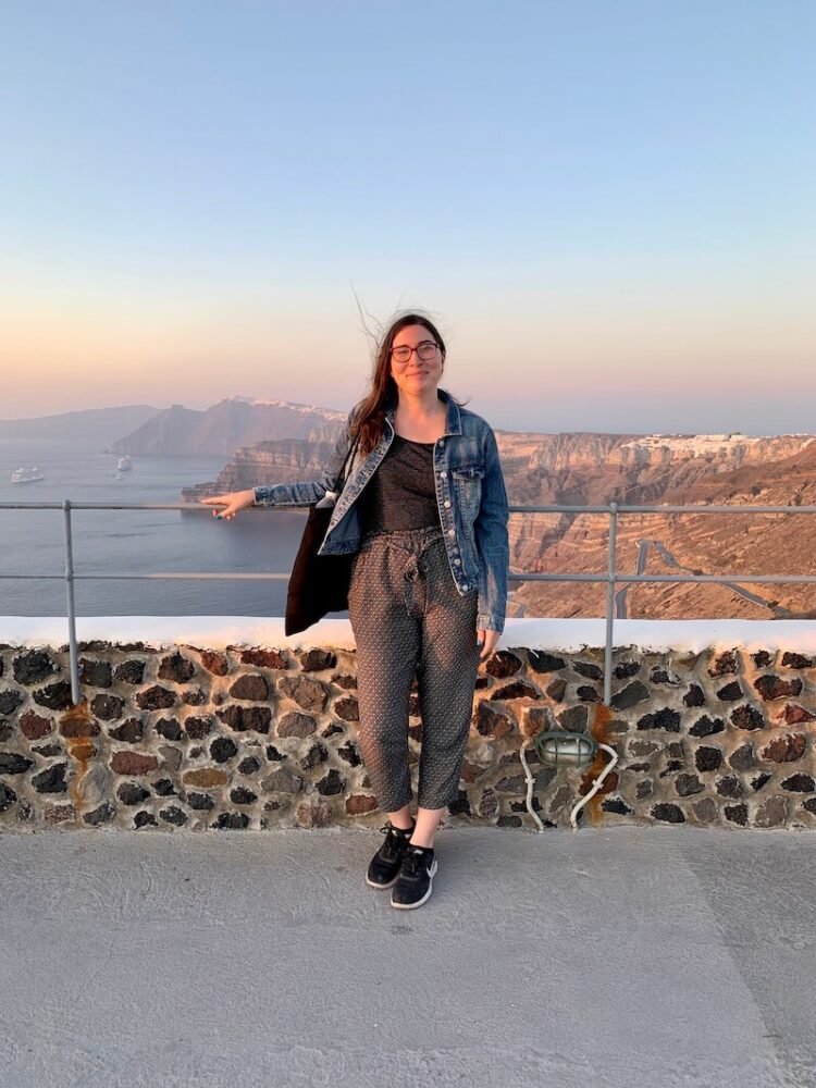 Allison Green standing in front of a Santorini sunset at the Venetsanos winery