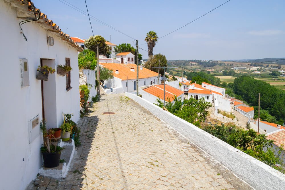 Typical white Houses in Aljezur village, calcada portuguese mosaic tilework floor and views to the land below it, whitewashed houses on the hill