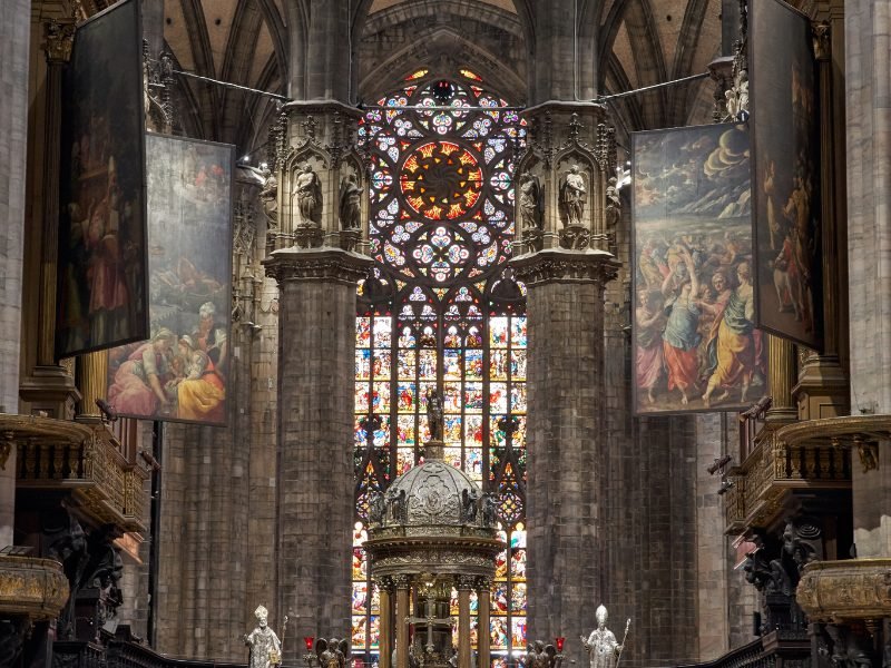 The detail of the stained glass apse in the Milan Duomo, as well as several hung tapestries, creating a rich variety of sights to see in the cathedral