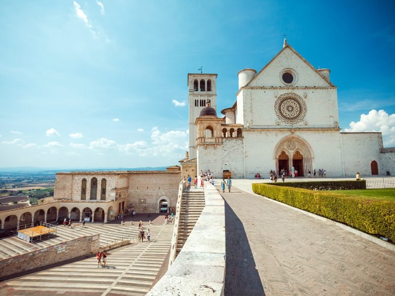 Marvelous basilica of Assisi dedicated to the patron saint, with views of the hills and countryside in the background, and a giant church