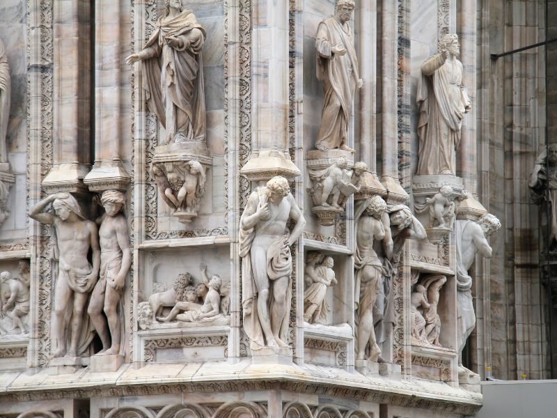 The detailed marble sculptures on the exterior of the Milan Duomo, several figures creating exquisite detail