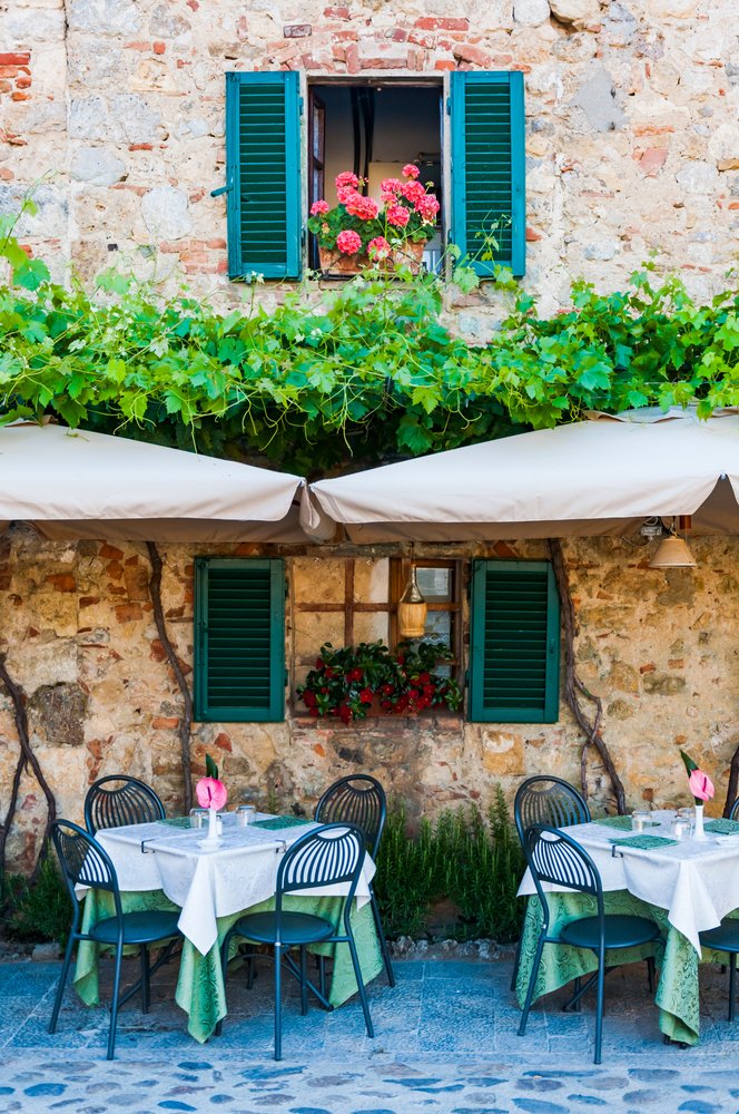 Tables of an Italian restaurant in the street of Monteriggioni, Italy