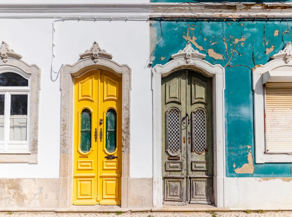 Doors to two different traditional houses, one abandoned and one being renovated in Olhao, Algarve