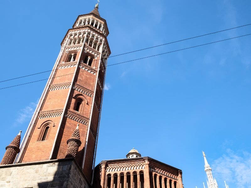 Belltower in famous chiesa di san gottardo in corte church on a sunny day in Milan with the duomo spires visible behind it.