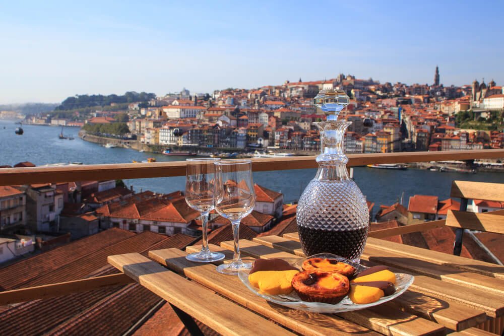 Table with wine and pastries in the view over the river in Porto, Portugal