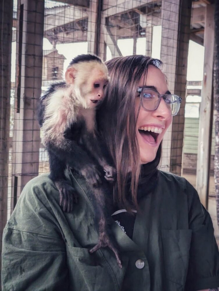 Monkey jumping on Allison Green's shoulder as she laughs ecstatically