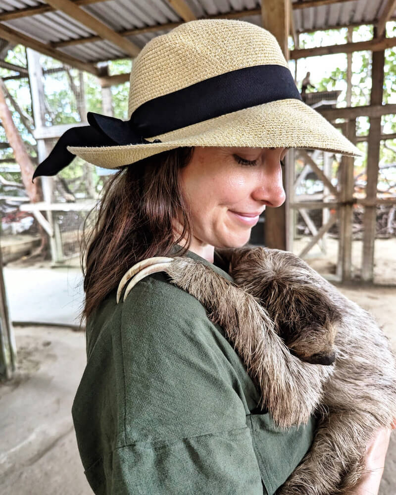 Allison green, the author of the article, holding a two-toed sloth at a sanctuary