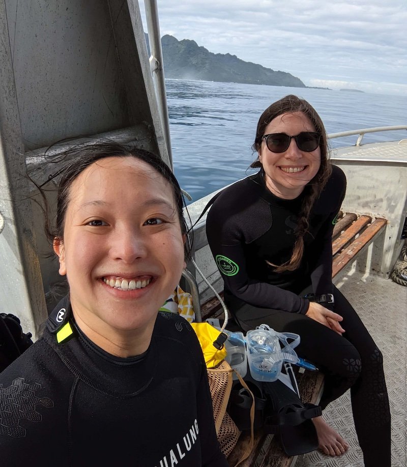 Allison Green and her partner diving in Moorea with the island visible in the distance