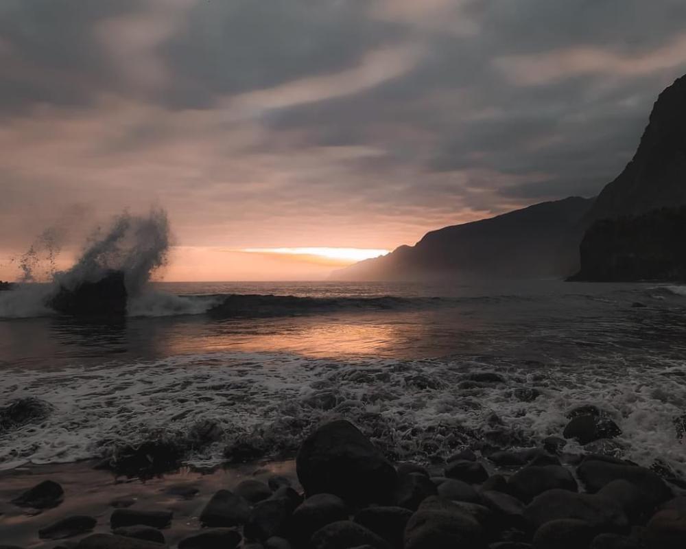 Stunning sunset at Praia Formosa with waves crashing into rock formations as the sun sets