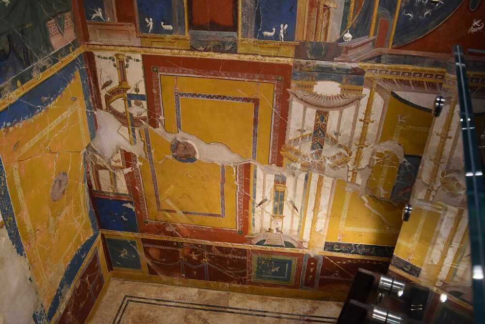 interior of a preserved villa from the roman times, with yellow red and blue painted fresco work