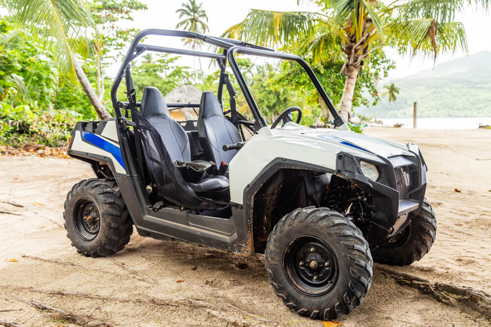 atv tour roatan with a atv on the beach and caribbean sea background