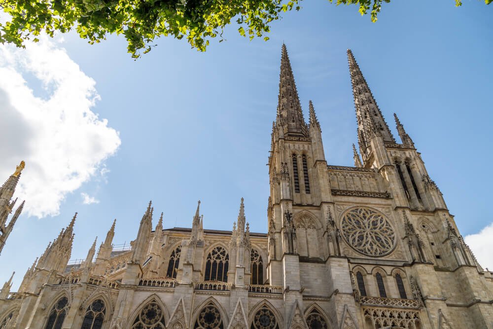 Facade of the Cathedral of Saint Andrew, with lots of gothic detailing and spires and domed windows on a sunny day 
