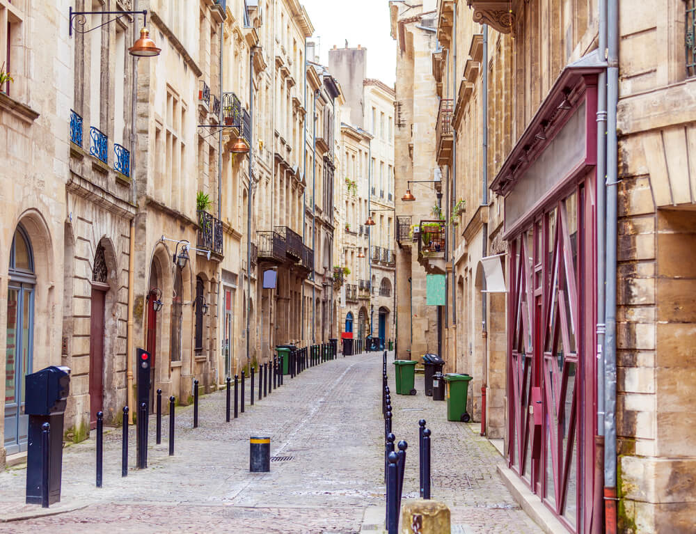 peaceful street in the old town center of bordeaux with stone facade architecture and small balconies